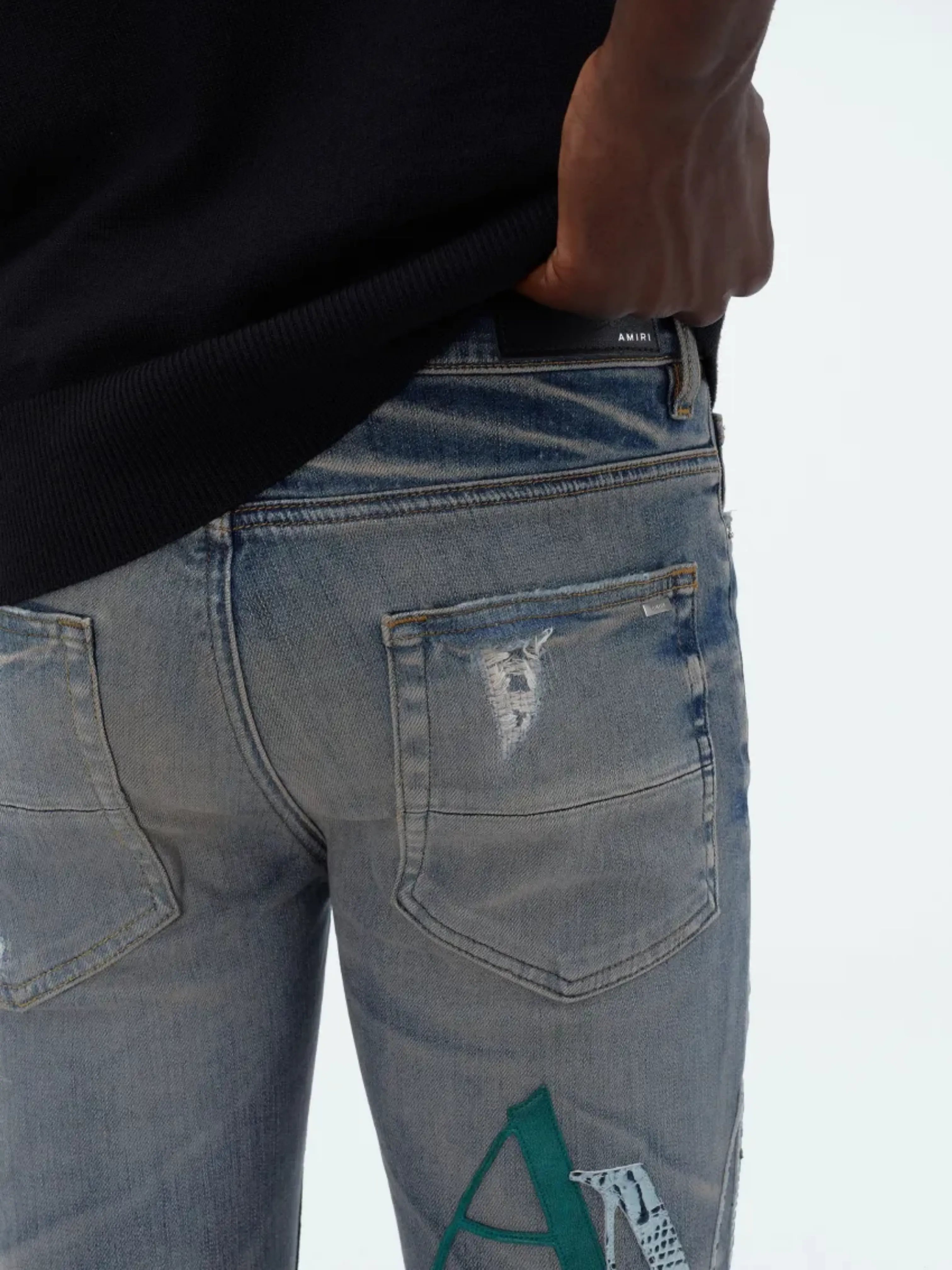 AMIRI STAGGERED LOGO JEANS INDIGO